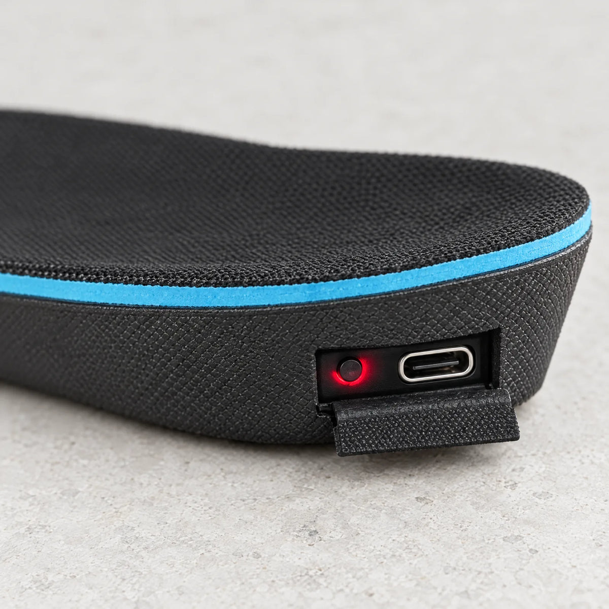 USB-C-Anschluss und Schalter mit LED an der Ferse der Sohle